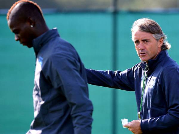 (FILES) In file picture taken on September 17, 2012 Manchester City's Italian manager Roberto Mancini (R) arrives with Manchester City's Italian forward Mario Balotelli (L) for a training session in Manchester, north-west England, ahead of their UEFA Champions League Group D football match against Real Madrid on September 18. Mario Balotelli's future at Manchester City was cast into doubt once again on January 3, 2012 after photographs emerged showing him in an apparent training-ground bust-up with manager Roberto Mancini. AFP PHOTO/PAUL ELLIS