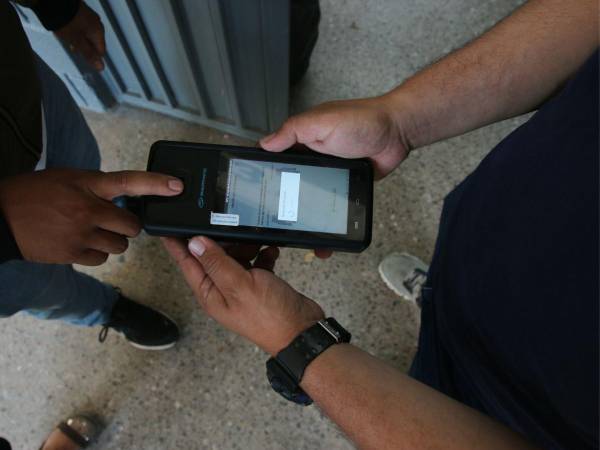 Los votantes haciendo uso del sistema biométrico el día de las elecciones.