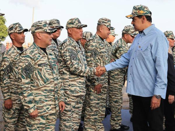 El presidente de Venezuela, Nicolás Maduro (d), saludando a miembros de la Milicia Bolivariana este jueves, en Caracas (Venezuela).