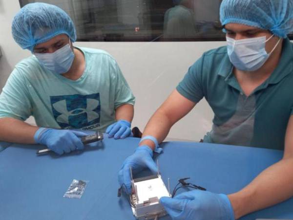 Dos dos integrantes del equipo del proyecto Morazán, ensamblaron el nano satélite en el cuarto limpio de Ciudad Universitaria.
