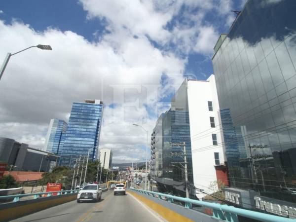 Vista de edificios en el paisaje urbano de Tegucigalpa captados desde el paso a desnivel que inicia en Casa Presidencial, donde el tránsito y las estructuras de concreto forman parte del escenario cotidiano.