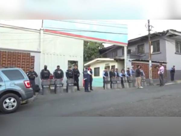 Varios agentes policiales resguardan la enttada principal de la SIT.