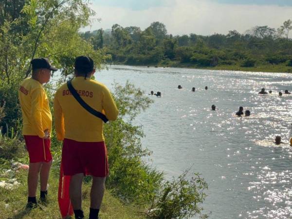 Elementos del Cuerpo de Bomberos durante la recuperación del cuerpo en el río Chamelecón, en Cofradía.