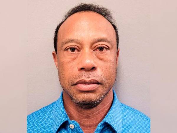 Tiger Woods es arrestado por agentes policiales tras verse involucrado en un accidente de tráfico.