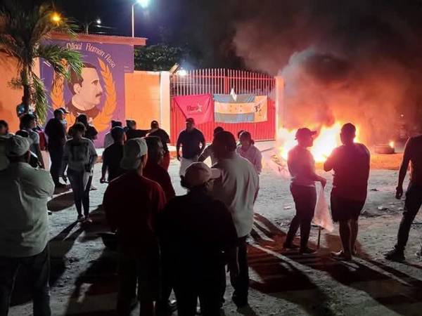 Simpatizantes del movimiento M28 de Libre protestan desde la noche del miércoles frente al Instituto Oficial Ramón Rosa en Tocoa, Colón, exigiendo la entrega de credenciales para los comités departamentales y municipales.
