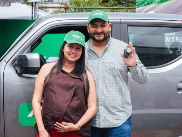 Alegría y gratitud en Tegucigalpa: Angelo Meléndez y su esposa posan frente al KIA Tasman, momento en que recibieron las llaves de su nuevo vehículo.