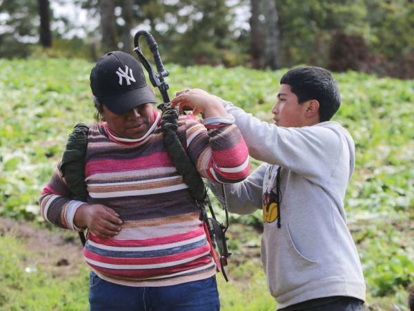 Emanuel Servellón, de 14 años, acompaña a su madre Carmen Leticia en las labores agrícolas, ayudándole con la bomba de fumigar las hortalizas en los cultivos de Lepaterique. Entre surcos y jornadas de trabajo, demuestra el valor del relevo generacional en el campo hondureño y el compromiso familiar con la producción de alimentos.