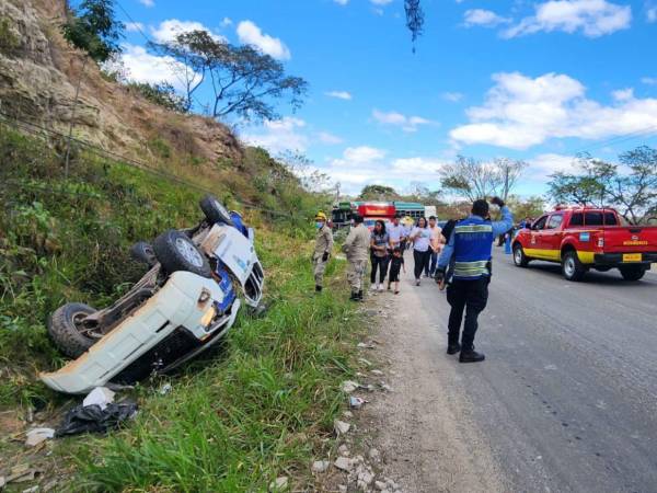 La patrulla en la que se transportaban los agentes policiales se salió de la carretera debido al fuerte impacto y quedó con las llantas hacia arriba.