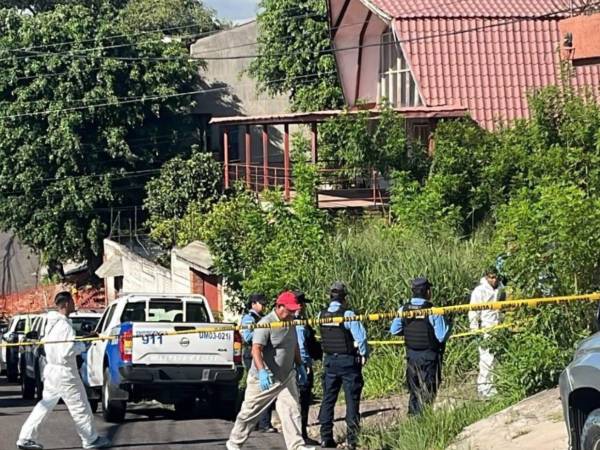 Agentes de la Policía Nacional acordonaron el lugar de la escena donde encontraron el cuerpo embolsado del hombre en un solar baldío en la colonia Miramontes de Tegucigalpa.