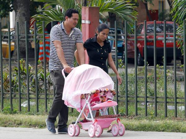 Imagen de archivo de una pareja que pasea con su bebé.