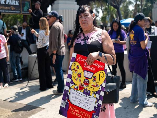 Fotografía cedida por la Coalición por los Derechos Humanos de los Inmigrantes (CHIRLA) que muestra a la ciudadana estadounidense Reyna posando con un cartel este martes, en Los Ángeles (Estados Unidos). EFE