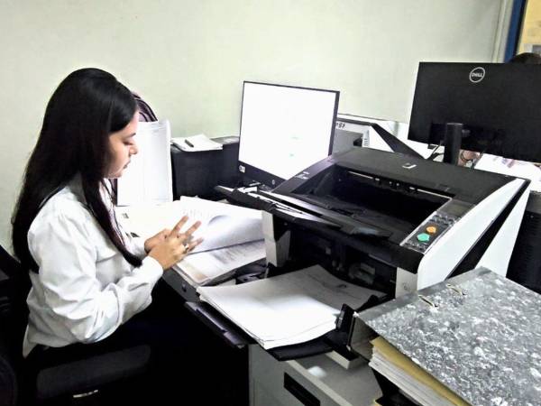 El personal del Instituto de la Propiedad realiza el proceso de escaneo de los documentos para ser digitalizados y con ello conservar la integridad de los libros registrales.