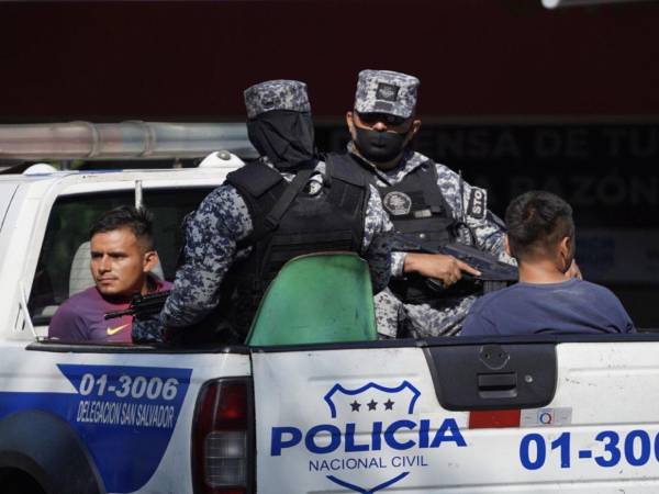 Dos personas son capturadas y llevadas en una patrulla de la Policía Nacional de El Salvador.