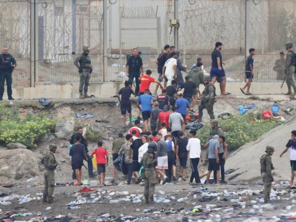 Los que han optado por salir de Ceuta se topan de frente con otros grupos de personas que siguen entrando en la ciudad.