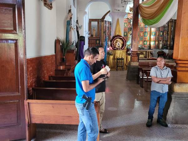 Agentes de la Policía Nacional realizan inspección en la oficina parroquial afectada por el ingreso de personas desconocidas en Juticalpa.