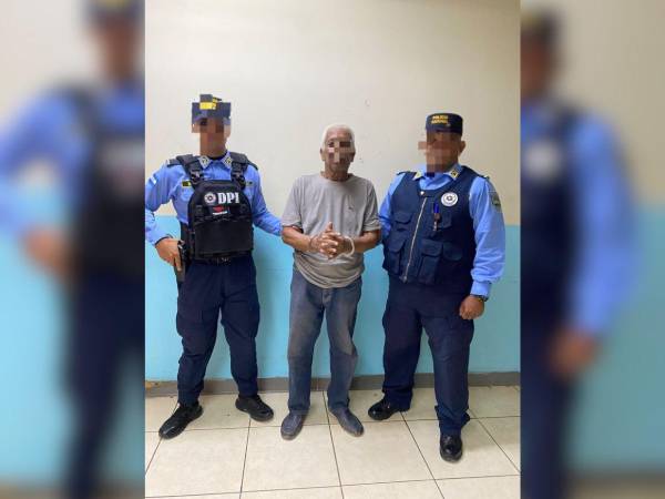 Agentes de la Dirección Policial de Investigaciones muestran al detenido, un hombre de 74 años.