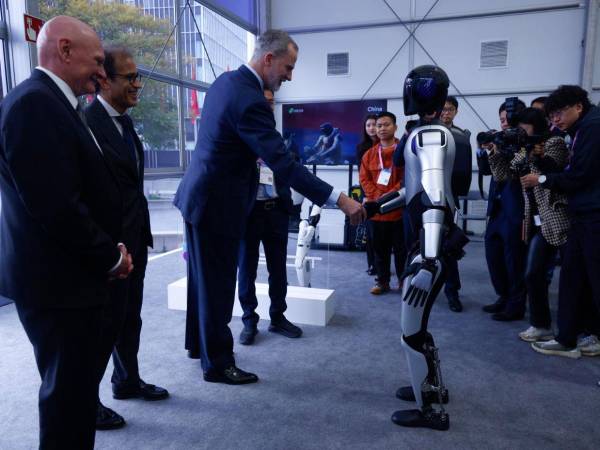 El rey Felipe VI saluda a un robot durante la vigésima edición del Mobile World Congress (MWC), este lunes en Barcelona, España.