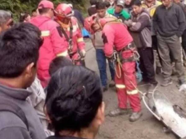 Bomberos y rescatistas trabajan en el lugar donde un autobús cayó por un barranco en la carretera hacia los Yungas, en La Paz, Bolivia.