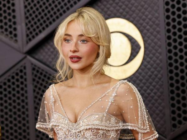 Sabrina Carpenter recorrió la alfombra roja de los Grammys 2026 luciendo un vestido largo en tono marfil completamente bordado con aplicaciones brillantes.