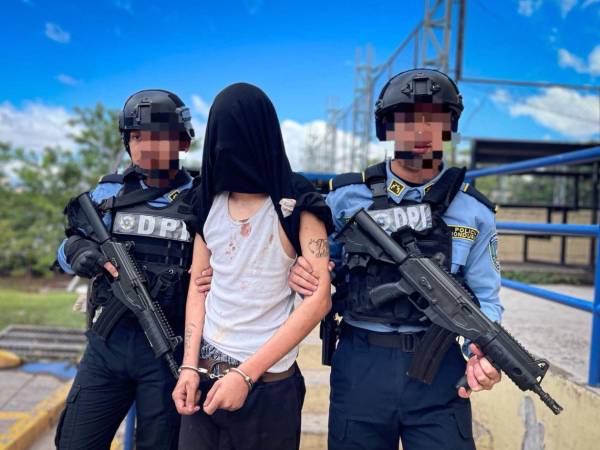 Un adolescente es aprehendido por agentes policiales. En Honduras, los menores pueden responder ante la justicia desde los 12 años bajo un régimen especial.