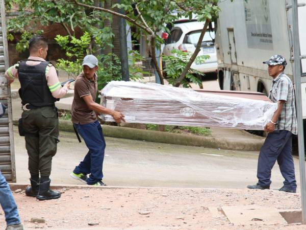 Familiares y compañeros de trabajo ingresan a la morgue del Ministerio Público (MP), el féretro para reclamar el cuerpo de Eslin Ostilio Alonzo Gonzáles.