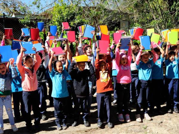 Niños y niñas sostienen sus nuevos cuadernos, símbolo de esperanza y compromiso con su educación durante la vigésima tercera edición de la campaña Maratón del Saber.