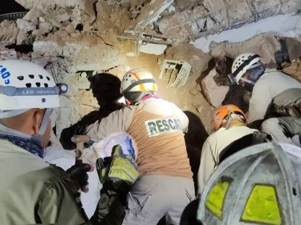 Momento en que el cuerpo de Karen Girón era rescatado de entre los escombros, entre hierros retorcidos, columnas quebradas y metros de tierra y rocas.