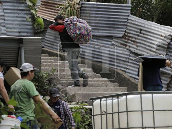 Los miembros de las familias desplazadas sacaron sus enseres envueltos en sábanas y cortinas.