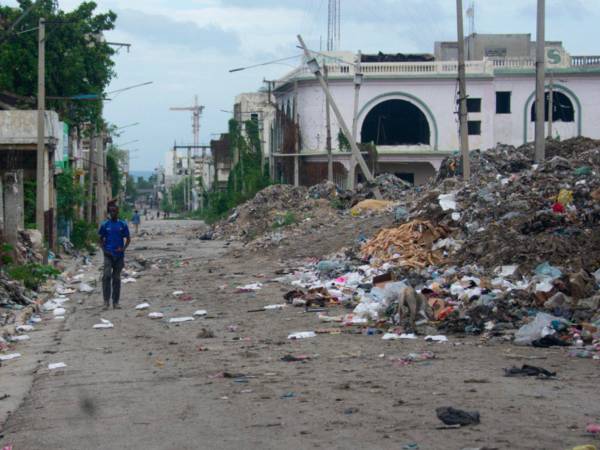 Un hombre camina por una calle del centro este sábado, mientras continúa la búsqueda de cuatro militares salvadoreños integrantes de la Fuerza de Supresión de Pandillas (GSF, sigla en inglés) desaparecidos tras sufrir una emboscada, en Puerto Príncipe (Haití).