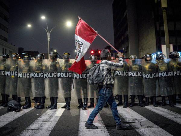La Policía Nacional del Perú dispersó este miércoles a los manifestantes que llegaron a los exteriores del Congreso después de que intentaron tumbar las rejas de seguridad y encendieron fuego cerca a los agentes policiales. Aquí las imágenes.