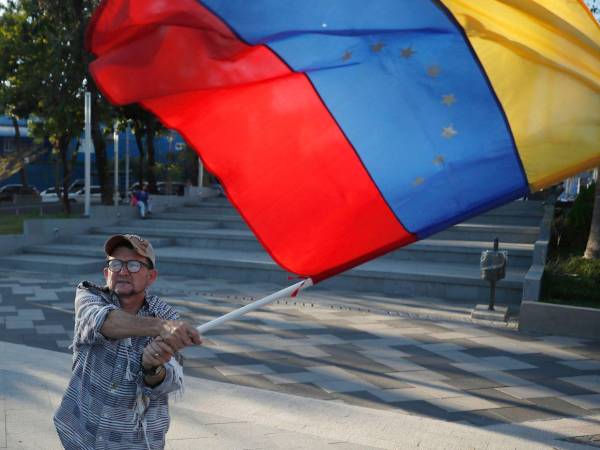 Un hombre ondea una bandera de Venezuela durante una manifestación en la plaza Simón Bolívar.