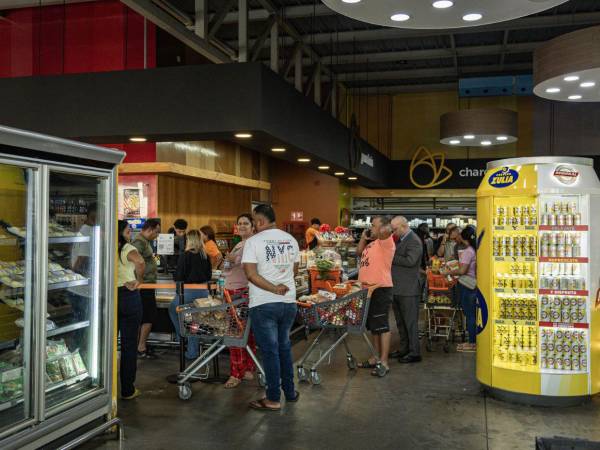 Miles de venezolanos forman largas filas, desde temprano, en los pocos supermercados que se mantienen abiertos para abastecerse de alimentos e insumos básicos.