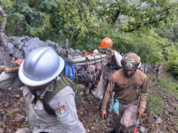 Fotografía muestra a miembros del Cuerpo de Bomberos rescatando el cuerpo de un hombre víctima de las lluvias, en Nacoame, departamento de Valle.