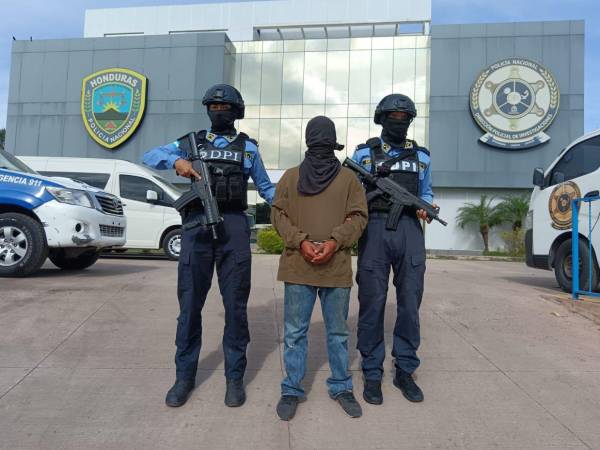 Dos agentes de la Dirección Policial de Investigaciones (DPI) custodian al menor de 17 años de edad, que habría ultimado a las dos personas.