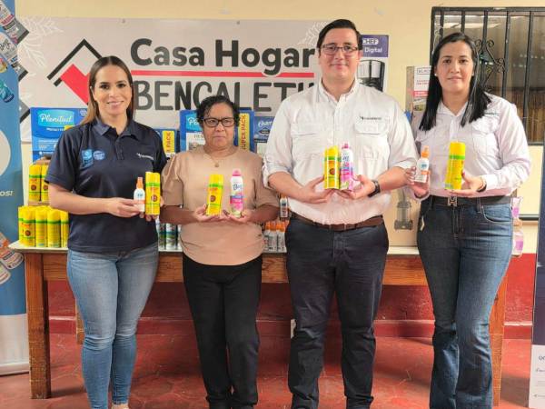 Ejecutivos de McBride (Caribbean) Limited entregan el lote de productos y electrodomésticos a la directora de la Casa Hogar Bencaleth, Dora Castellanos.