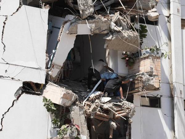 Al menos 20 edificios sufrieron graves daños por consecuencia del terremoto. Personas salen de los escombros de un edificio colapsado en el departamento del Valle del Cauca.