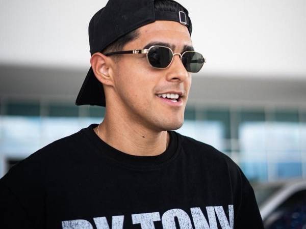 Luis Palma sonríe a su llegada al aeropuerto Ramón Villeda Morales, donde fue recibido por medios y aficionados que celebraron su regreso al país.