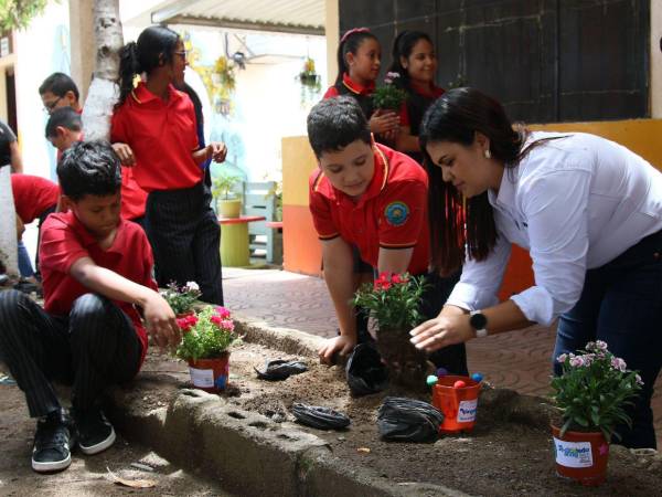 Lynda Marín, gerente de Asuntos Corporativos de Nestlé, entrega plantas a los estudiantes y les enseña a reciclar maceteras como parte del programa Reciclando ando con Nestlé.