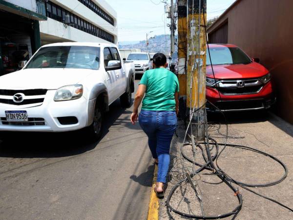 Vecinos y comerciantes alertan sobre cables caídos en la avenida Juan Ramón Molina, detrás del Congreso Nacional, los cuales permanecen desde hace tres semanas sin atención.