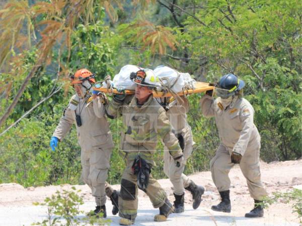 Miembros del Cuerpo de Bomberos de Honduras descendieron hasta un pequeño abismo de aproximadamente 75 metros para rescatar los tres cuerpos carbonizados que fueron hallados la mañana de este martes 12 de mayo, en una zona boscosa del cerro de la aldea El Cimarrón, en Francisco Morazán.