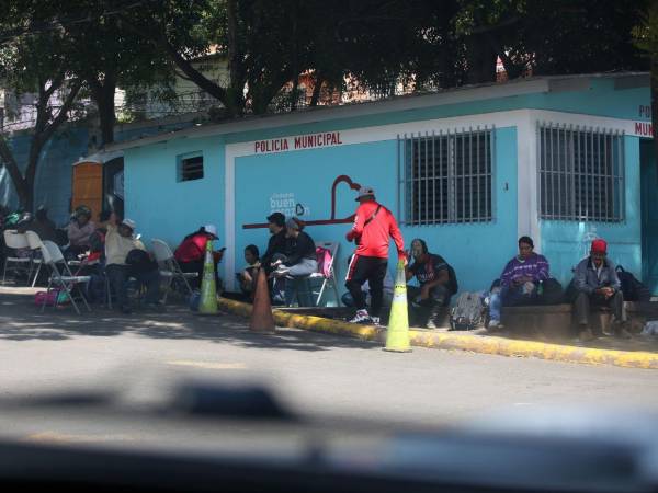 Sentados en sillas, en las aceras del plantel de la Alcaldía Municipal del Distrito Central (AMDC), en la colonia 21 de Octubre, pasan los miembros de los colectivos de Libre.