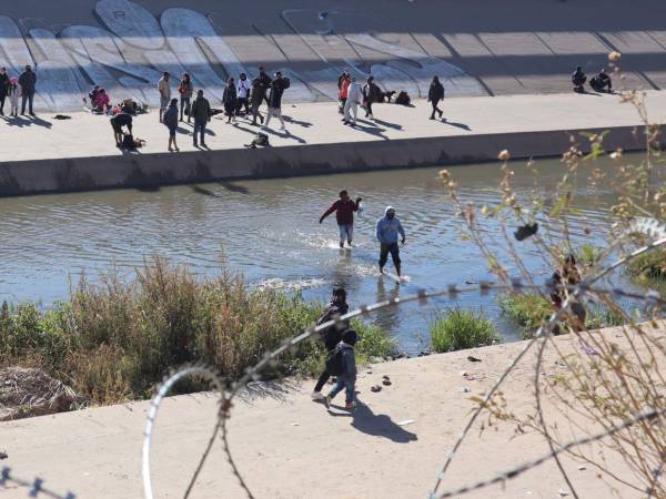 Fotografía de archivo tomada desde la valla fronteriza de El Paso, Texas, de migrantes cruzando el río en la zona de Ciudad Juárez, México.