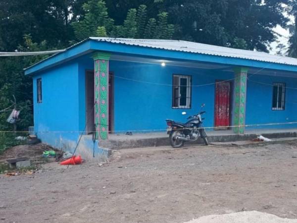 Agentes policiales acordonaron la vivienda en Salitrán, Atlántida, donde fueron asesinados Santos Vásquez y su hijastro Ángel Rivera.