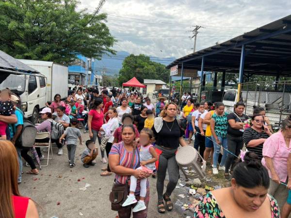 Decenas de personas seguían este martes a las afueras de la escuela Soledad Fernández del barrio Barandillas en San Pedro Sula esperando la entrega del bono climático.