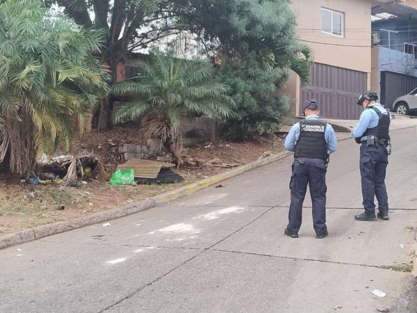 Escena del crimen en la calle principal de la colonia La Esperanza, donde un hombre fue hallado sin vida con múltiples impactos de bala.