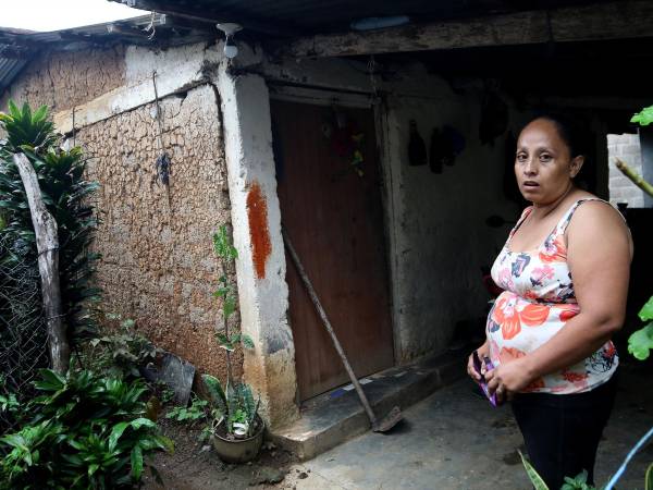 Lesly Flores vive en Las Lajas, Comayagua. Al fondo se ve la casa que abandonó en 2023 porque los sismos provocaron que las paredes se dañaran; en este 2025 volvió a ocuparla porque no tenía dónde vivir.