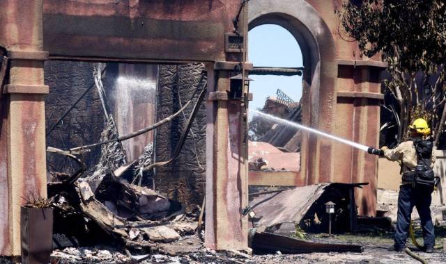 Un bombero trabaja para apagar puntos críticos en una de las más de 20 casas destruidas por el incendio costero el 12 de mayo de 2022 en Laguna Niguel, California.