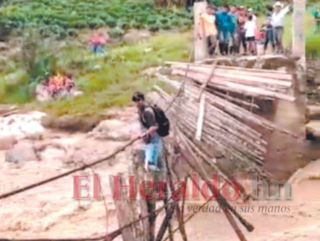 Un voluntario de Salud arriesga su vida al pasar un río en el municipio de Opalaca, Intibucá.