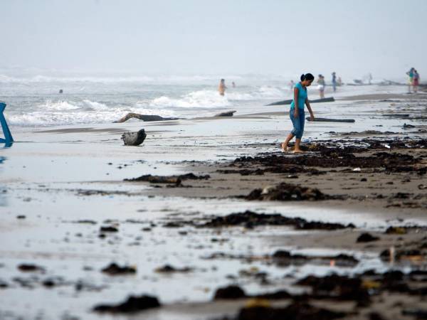 Turistas nacionales se aventuran a adentrarse en el mar picado en la Playa Bagdad, 38 kilómetros al este de Matamoros, estado de Tamaulipas (México).