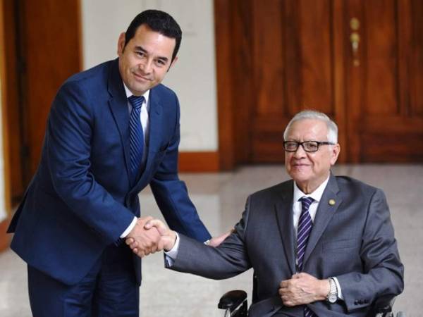 El actual presidente de Guatemala, Alejandro Maldonado estrecha su mano con el presidente electo, Jimmy Morales.